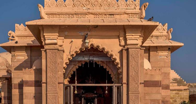 Façade d'un ancien temple de pierre avec des sculptures ornementales.