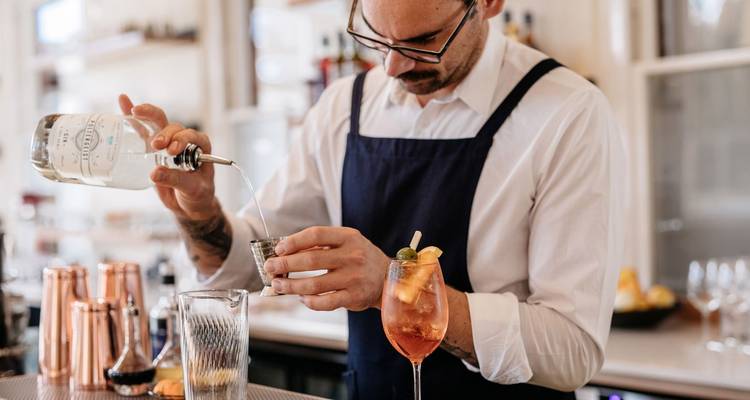 Bartender preparing a cocktail with care.
