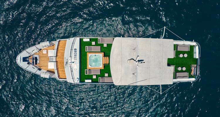 Vista aérea de un yate de lujo con asientos y un jacuzzi en el océano.