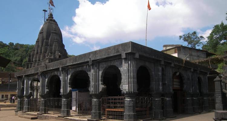 Ancient temple with a black stone facade and a dome.