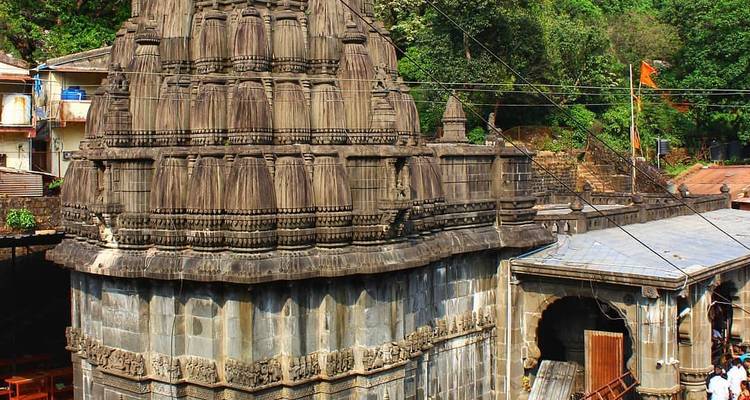 Stone-carved temple tower amid green forest (duplicate view)