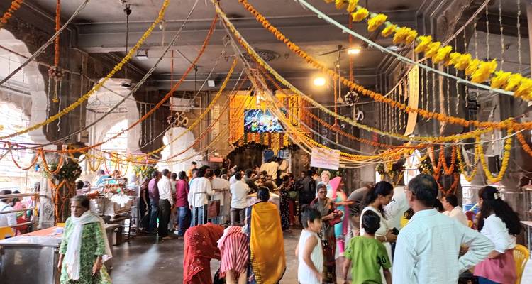 Crowded interior of decorated temple hall with devotees (duplicate)