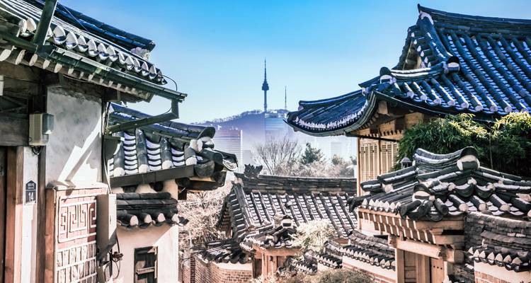Traditionelle Ziegeldächer des Bukchon Hanok Village mit dem Namsan Seoul Tower im Hintergrund.