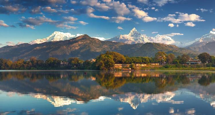 Majestic mountains reflected in a calm lake under a blue sky.