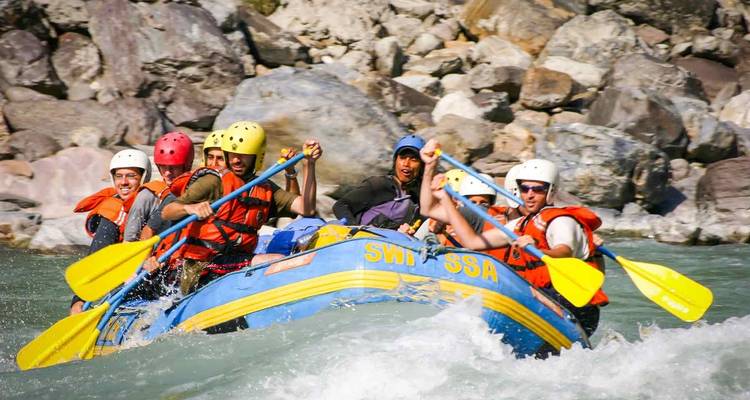 Group of people white-water rafting on a river.
