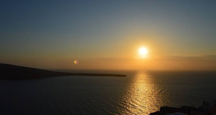 Coucher de soleil serein sur la mer avec un horizon lumineux.