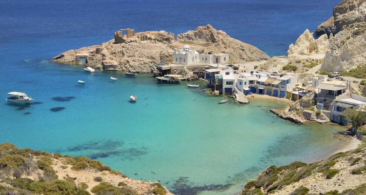 Turquoise bay with white houses and boats in Milos.