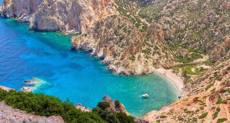 Secluded bay with turquoise water and rocky surroundings in Milos.