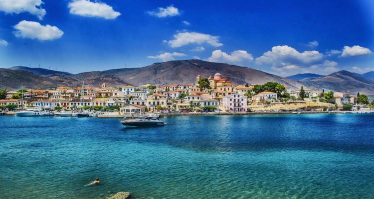 Küstenstadt mit bunten Gebäuden am Meer, Schwimmer im Wasser.