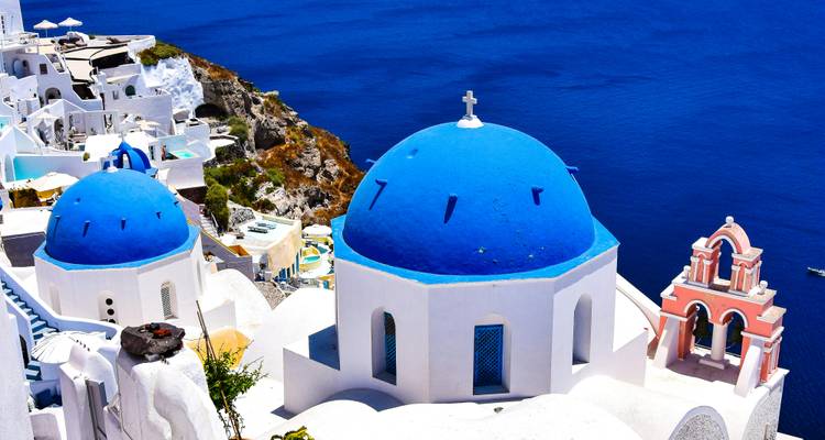 Edificios icónicos de cúpulas azules con vista al Mar Egeo.