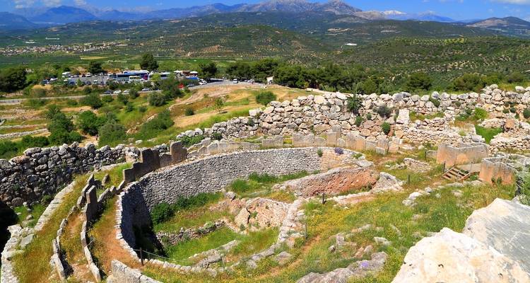 Ruines anciennes avec structure circulaire et paysage verdoyant.