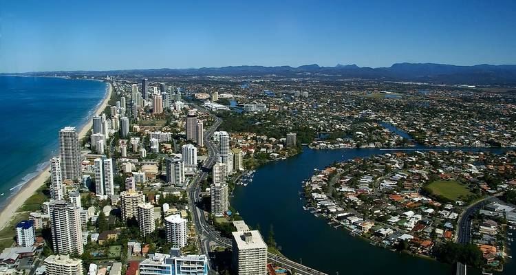 Luchtfoto van een uitgestrekte stad langs de kustlijn.