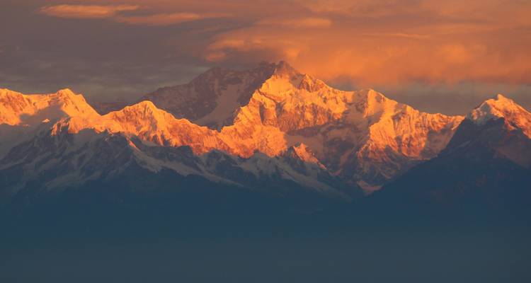 Vue du coucher de soleil sur les sommets de l'Himalaya avec une lueur chaleureuse.