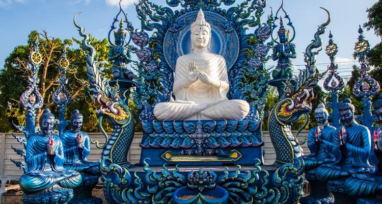 Intricately detailed blue and gold Buddha shrine with mythic serpent statues.