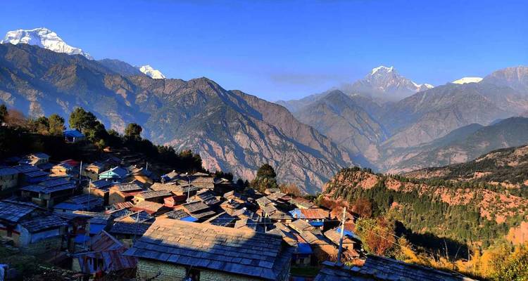 Nepalees dorp genesteld in de bergen met dramatische toppen.