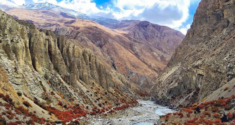 Paisaje montañoso dramático con río en el valle.