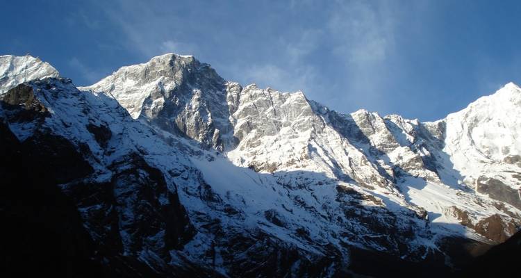 Schneegipfel vor blauem Himmel.
Or more literally: Schneebedeckte Berggipfel vor blauem Himmel.