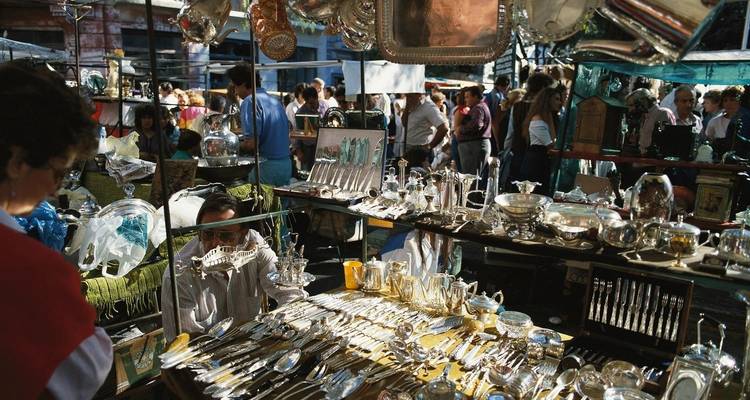 Puesto de mercado con varios artículos de platería y gente navegando en Buenos Aires.