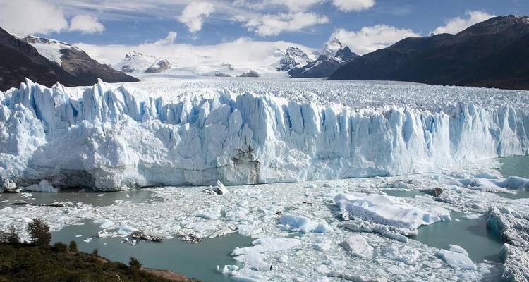 A stunning view of the Perito Moreno Glacier with rugged mountains in the background.