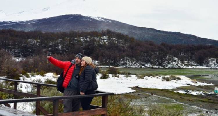 Couple taking a selfie in a snowy landscape with mountains.