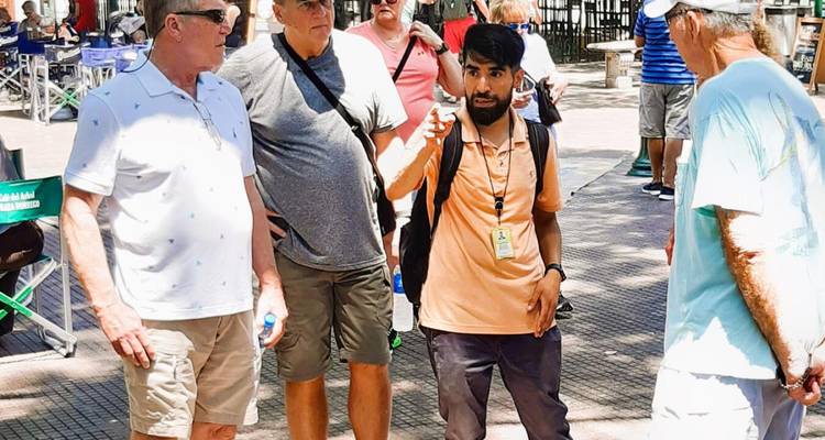 Groupe de touristes écoutant un guide sur une place.