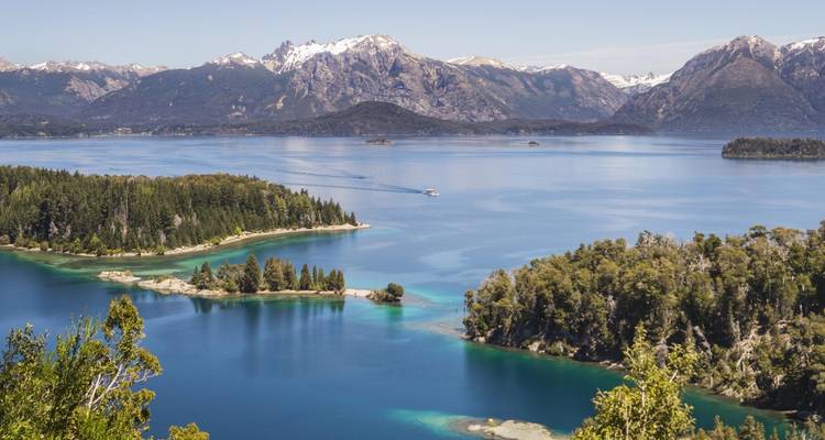 Una vista aérea de un lago impresionante con islas y montañas distantes.