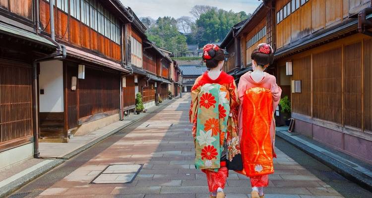 Deux femmes en kimonos traditionnels marchant dans une rue historique.