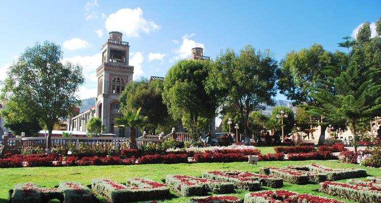 Lebendiger Stadtpark mit einem Uhrenturm und Gärten.
