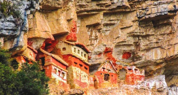 Bunte antike Strukturen, die in eine Felswand hineingebaut sind.