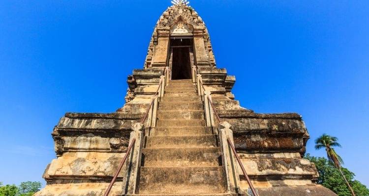 Hohes Steinmonument mit Stufen, die nach oben führen, unter einem klaren blauen Himmel.