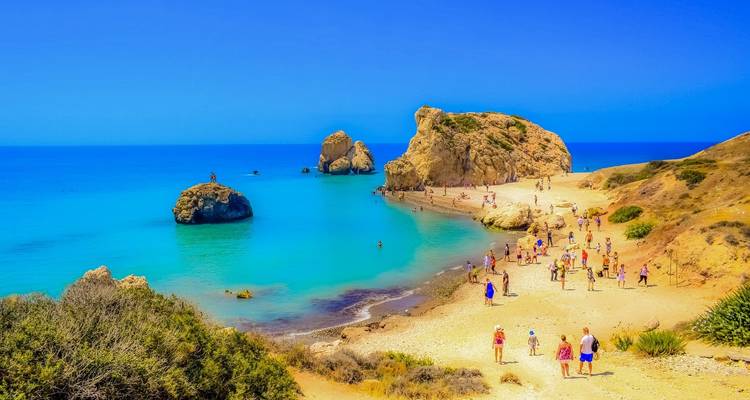 Sunny beach with people swimming and relaxing.