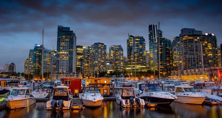 Vancouver haven 's nachts met boten en verlichte gebouwen.