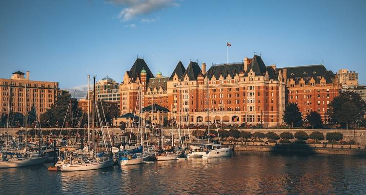 Historic building with marina and yachts in the foreground, lit by warm light.