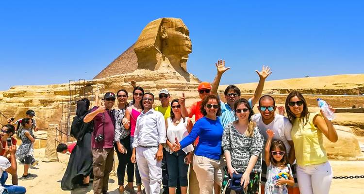 Gruppe von Touristen, die mit der Sphinx posieren.