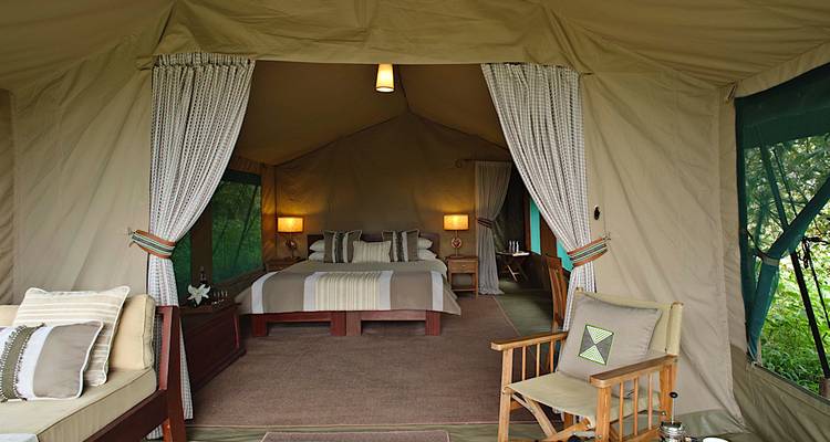 Intérieur de tente luxueux avec lit et coin salon.