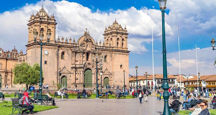 Plein met een historische kerk omringd door mensen.