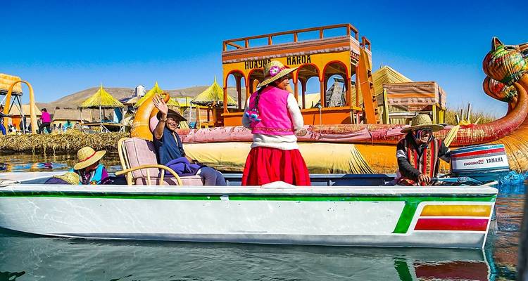 Traditionele boten met mensen in kleurrijke kledij op een meer.