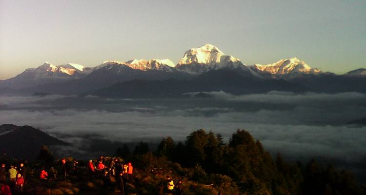 Gebirgskette mit schneebedeckten Gipfeln bei Sonnenaufgang.