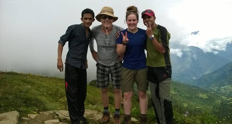 Gruppe von Menschen, die für ein Foto mit Bergen im Hintergrund posieren.