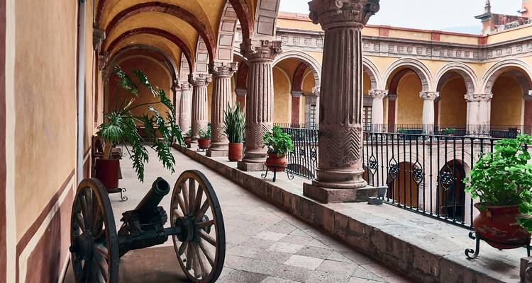 An arched corridor with historic artifacts on display.
