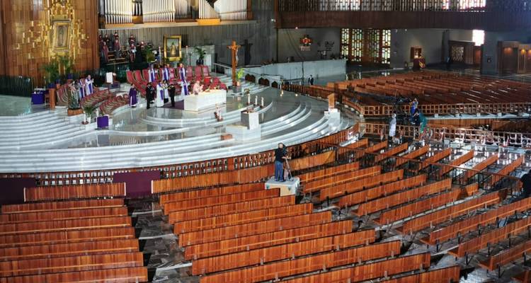 A large church interior with rows of seating and a central altar.