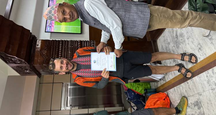Deux hommes à l'intérieur d'un bâtiment, l'un recevant un certificat.