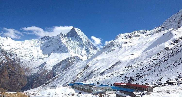 Bâtiments au pied de montagnes enneigées.