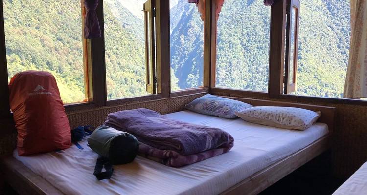 Lit douillet près des fenêtres avec vue sur une vallée.