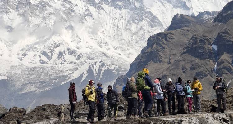 Groupe de randonneurs debout avec des montagnes en arrière-plan.