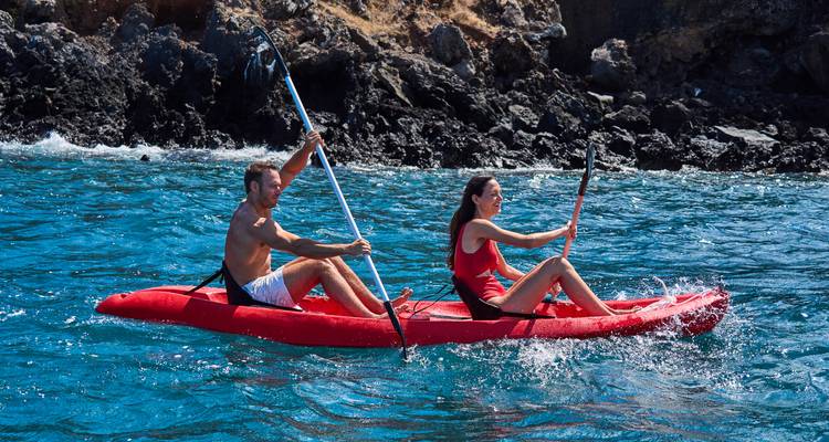 Couple faisant du kayak près d'une côte rocheuse.