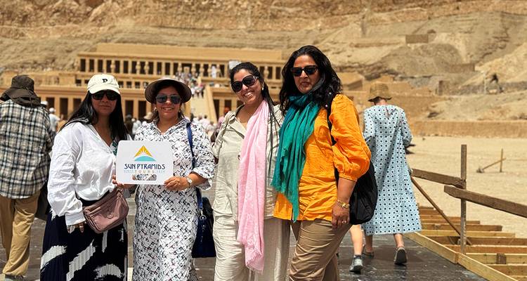 Groupe de quatre femmes posant devant un temple ancien.