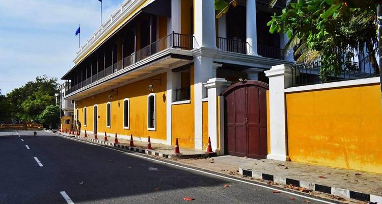 Une rue pittoresque avec un bâtiment jaune à l'architecture coloniale.