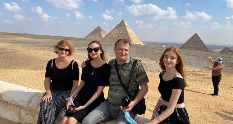 Family sitting in front of the Pyramids of Giza.