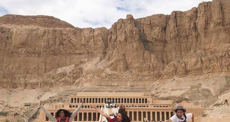 Un groupe de personnes qui sautent avec les bras levés devant un temple.